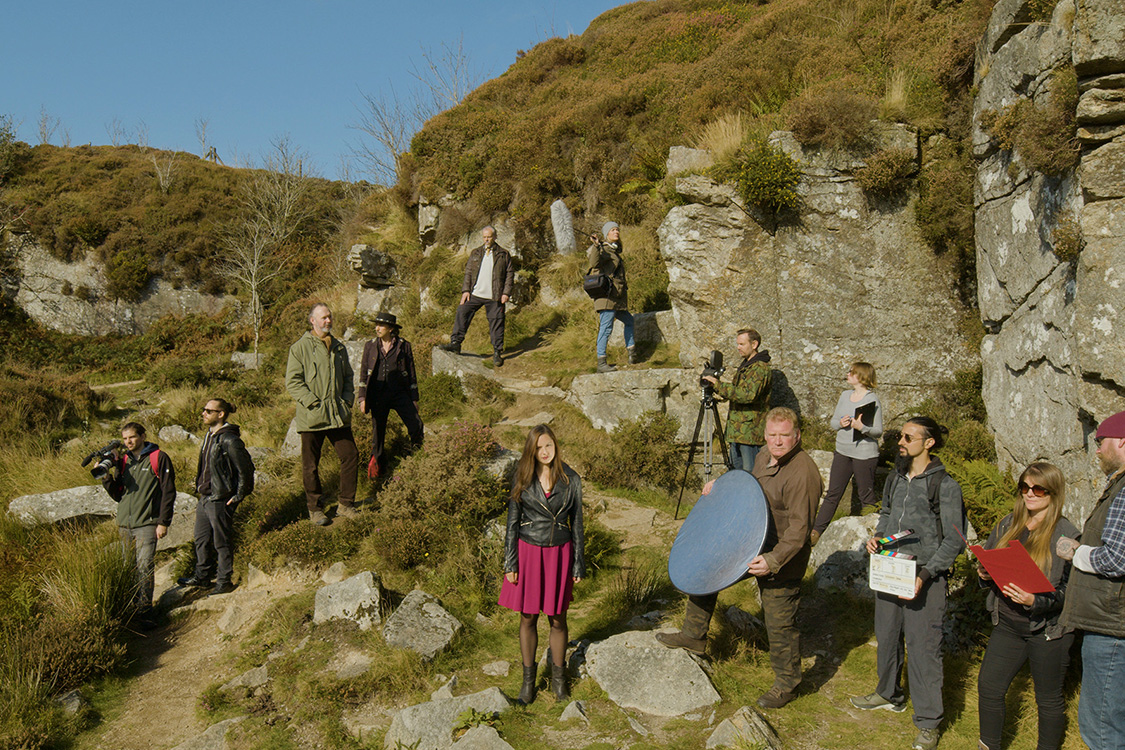 A group of actors filming on a moor.