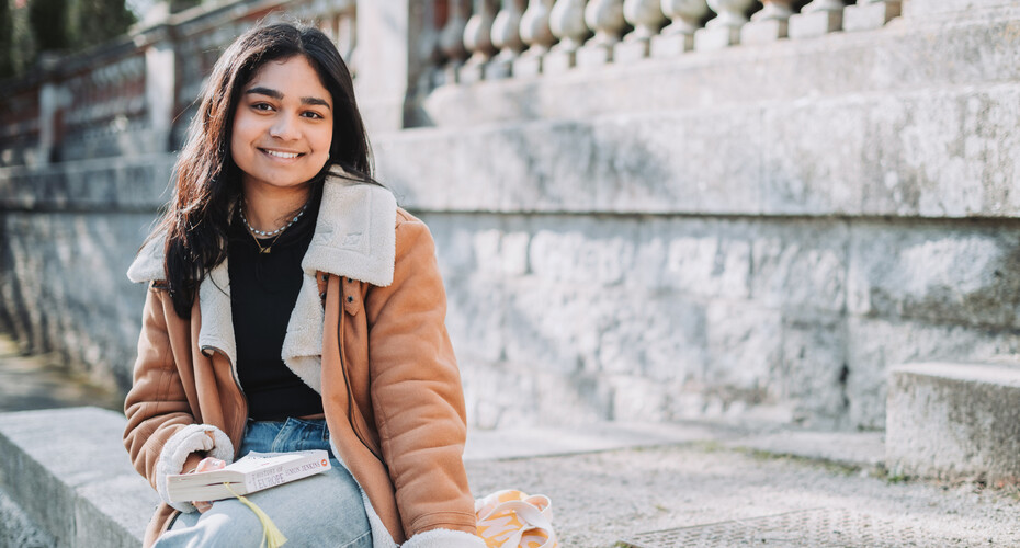 A student on the steps of Reed Hall
