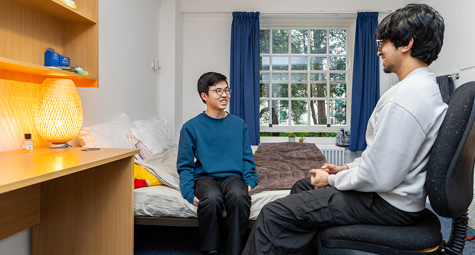 Students sat chatting in a bedroom in Lopes Hall