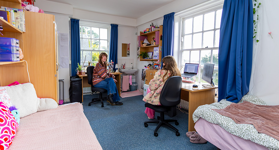Students sat chatting in a twin bedroom in Lopes Hall