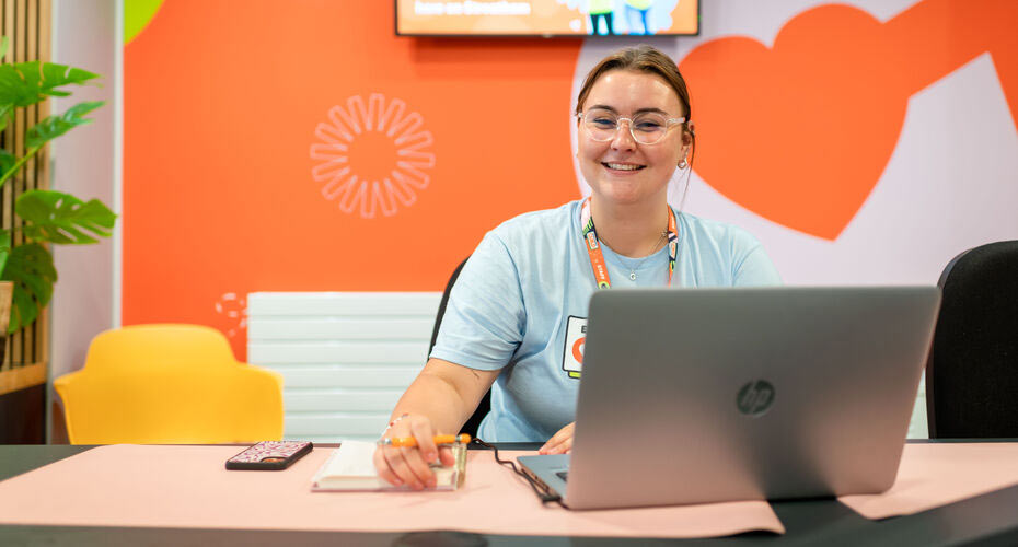 A student member of staff sat at an advice desk