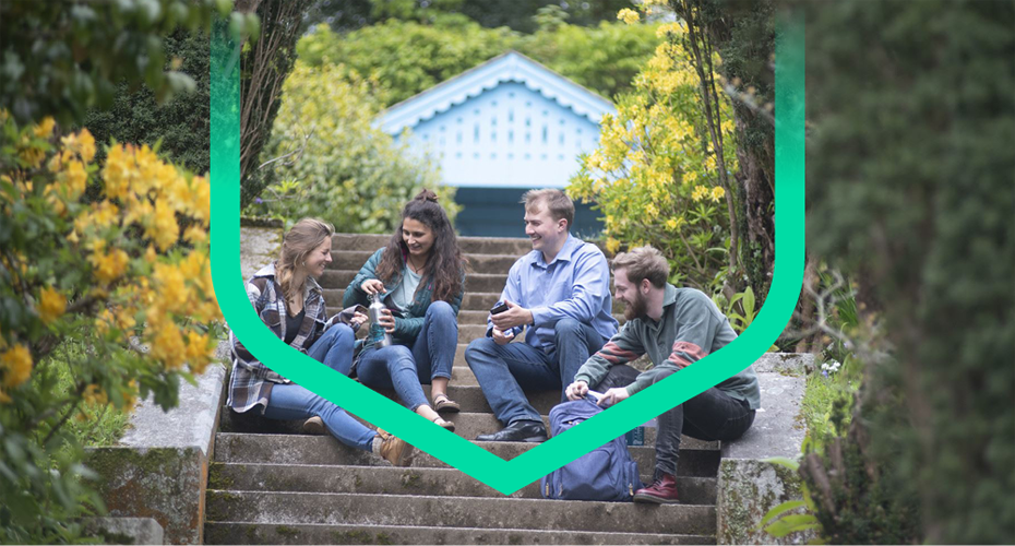 Students seated on garden steps, engaged in conversation and enjoying the serene outdoor environment.