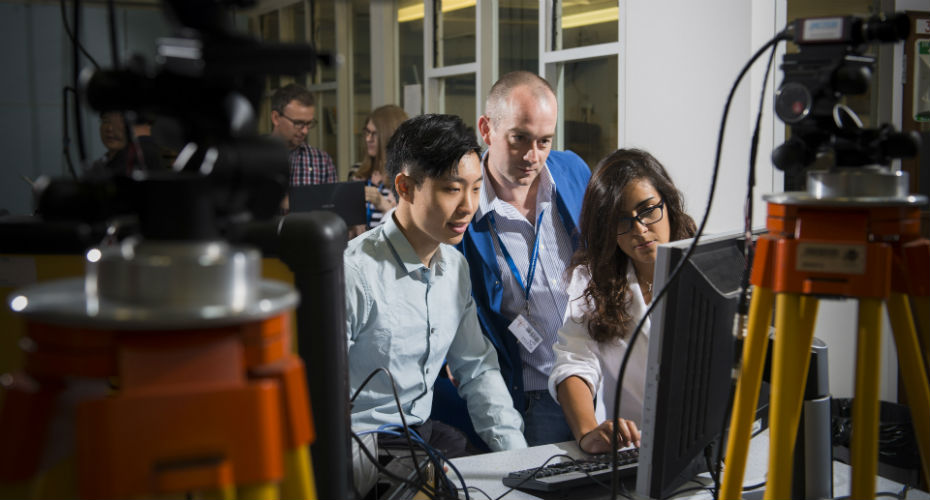 Several people engaged in teamwork at a computer, sharing ideas and working together in a professional environment.